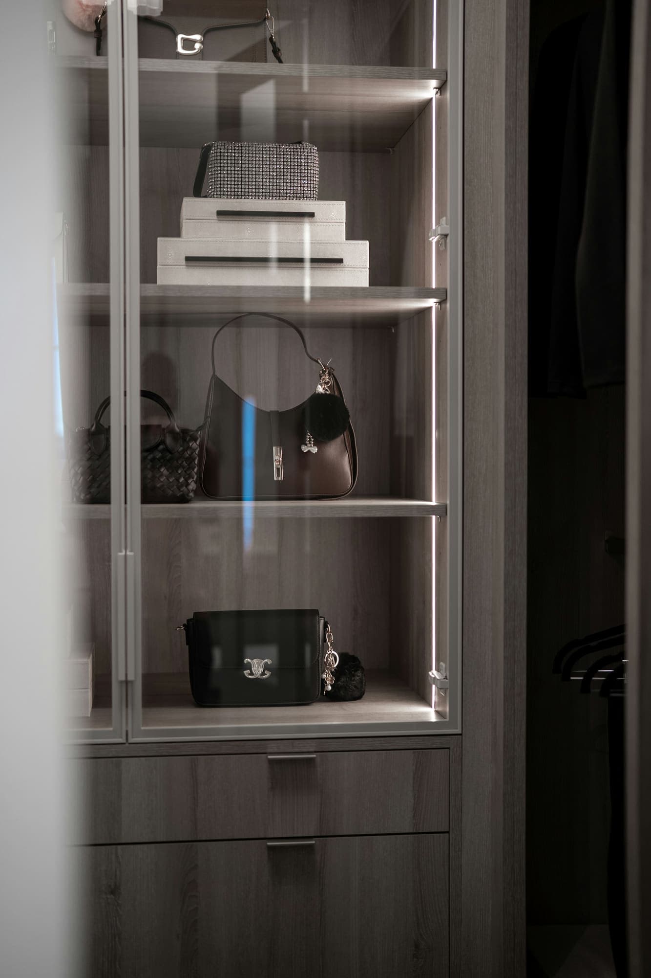Glass display case with handbags and boxes